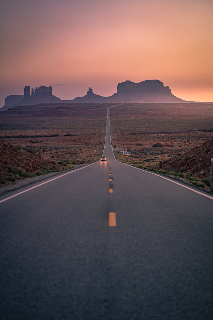 Services Dramatic road leading to Monument Valley with a stunning sunset sky.